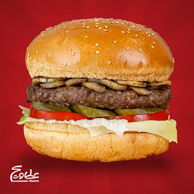 یک عدد برگر 160 گرمی ، قارچ ، گوجه فرنگی ، نان گرد رومال دار کنجدی ، خیار شور و کاهو قارچ برگر